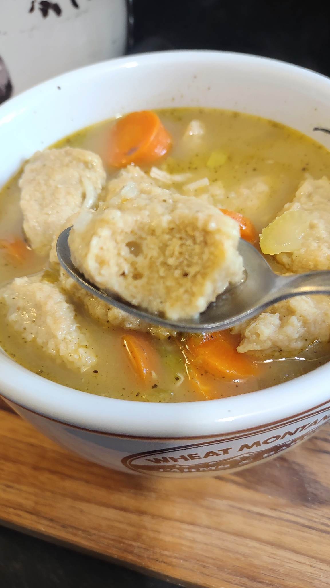 egg drop dumpling on a spoon above turkey soup