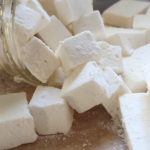 homemade marshmallows cut into squares laying on a cutting board