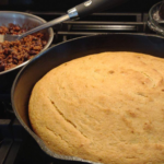 sweet cornbread in cast iron skillet made with fresh milled flour and corn on stovetop