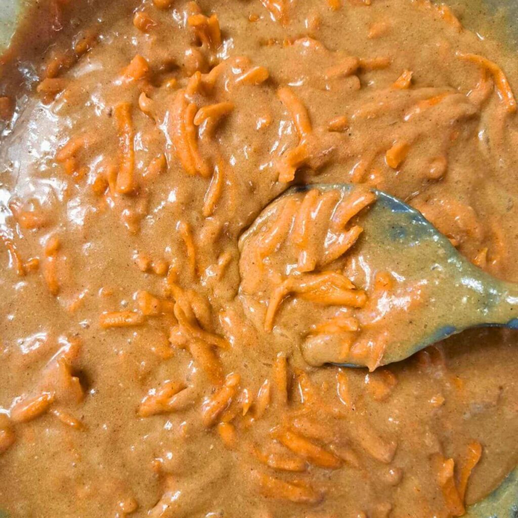 adding carrots into carrot cake batter