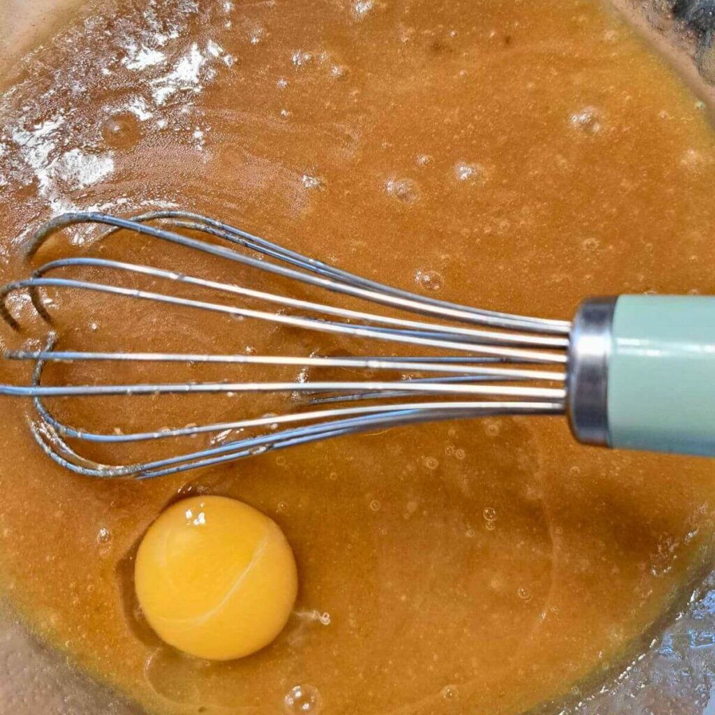 adding egg to carrot cake batter