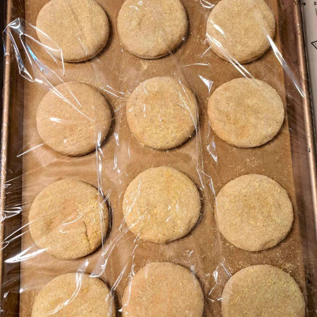 english muffins covered with plastic wrap to rise