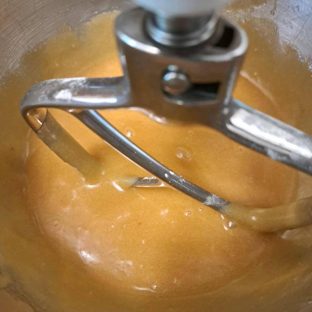 melted butter, sugar, and brown sugar in a mixing bowl with vanilla extract and eggs