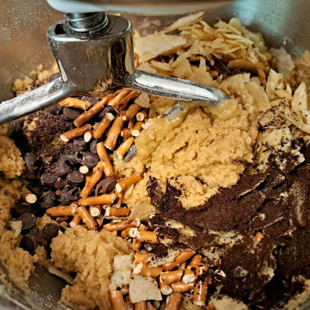 compost cookie dough with chocolate chips, pretzels, potato chips, and coffee grounds mixed in
