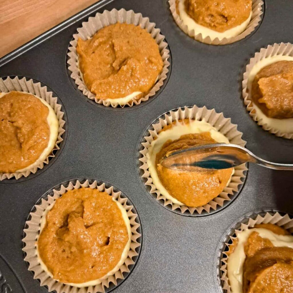 layering muffin batter and cheesecake filling 